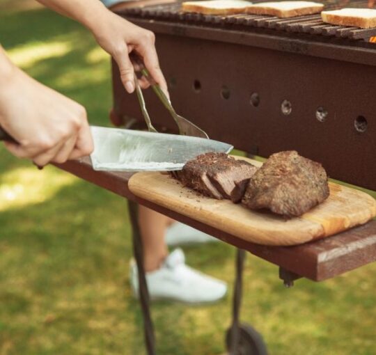 foto de homem cortando carne de churrasco em cima de tabua