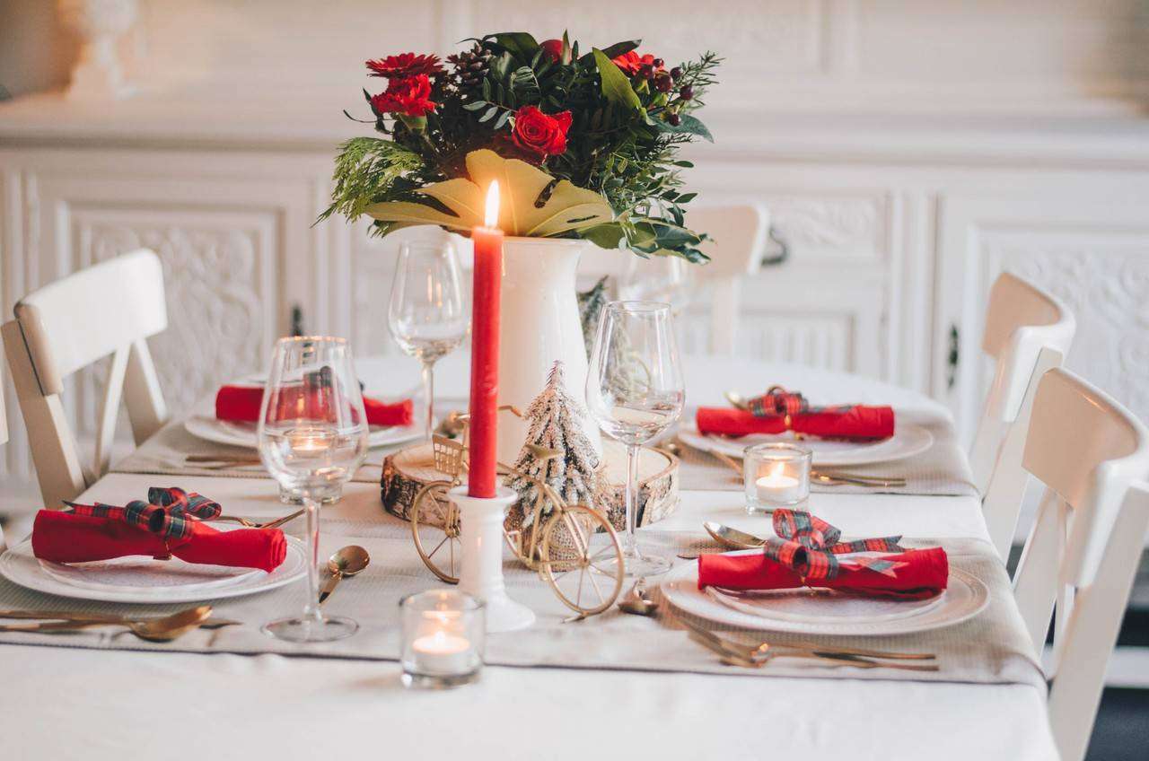 Mesa de ceia montada com detalhes em vermelho e branco